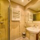 Łazienka z kabiną prysznicową i umywalką w Apartamencie Tetmajera 1